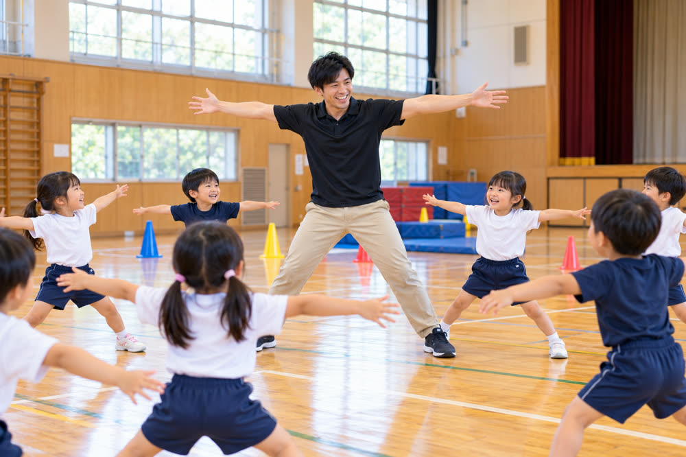 見本を見せながら子どもと体を動かす指導者
